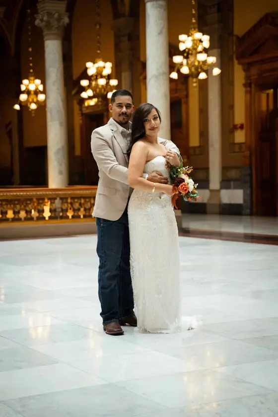Bride and groom beneath chandeliers at the Indiana Statehouse by Ken Floyd Media